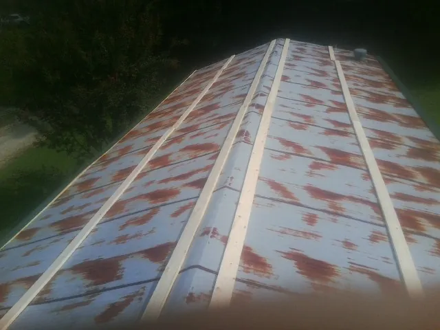 Rusted metal roof panels with new wood purlins before replacement — Storm Damage Roof Repair in Owosso by Roofing Brothers