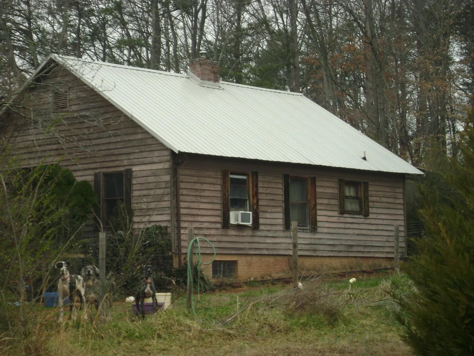 White metal roof on an old wood sided farmhouse, from a Metal Roof Installation job in Owosso